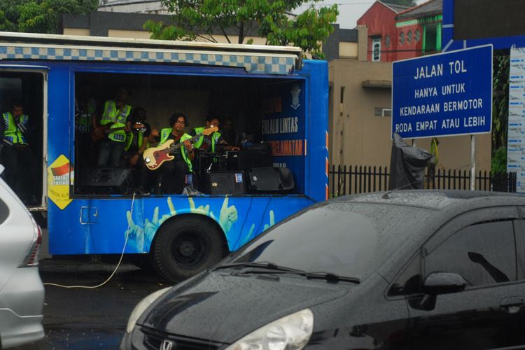 Satlantas Polres Bogor memberikan suguhan live music kepada para pengendara yang terjebak macet di Simpang Gadog, Puncak, Bogor, Jawa Barat, Sabtu (24/3/2018).