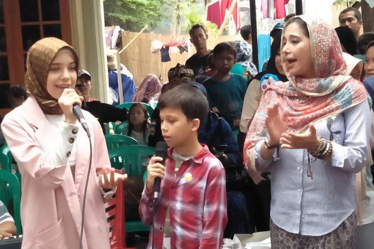 Ayu Khadijah Azhari bersama kedua anaknya, yakni Isabelle dan Lenon Tramp, melakukan bakti sosial dengan memberikan bantuan sekaligus menghibur para keluarga korban tsunami di desa Sukarame Labuan dan Desa Teluk, Banten pada Sabtu (19/1/2019) lalu.