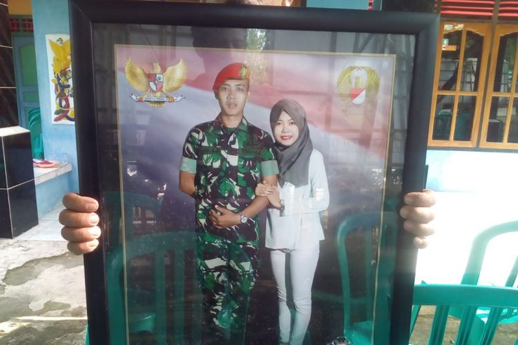 Suraidi Iskandar menunjukkan foto putranya, Serda Siswanto Bayu Aji (24), berdampingan dengan kekasihnya, Gilang, saat ditemui di rumah duka di Desa Mojorebo, Kecamatan Wirosari, Kabupaten Grobogan, Jateng, Jumat (8/3/2019).