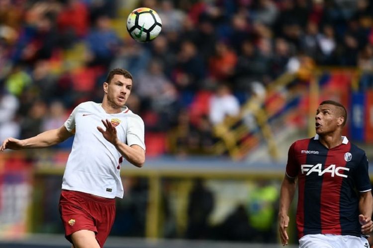 Sebastian De Maio (kanan) dan Edin Dzeko mencoba mengejar bola pada pertandingan Serie A antara Bologna dan AS Roma di Stadion Renato dallAra, Sabtu (31/3/2018).