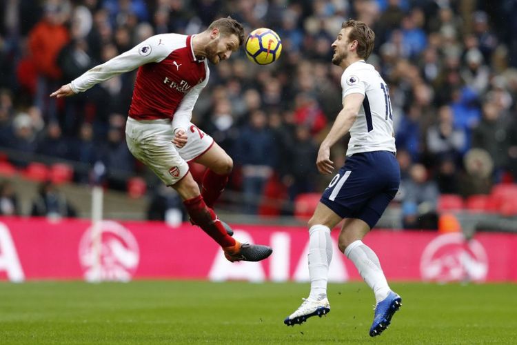 Shkodran Mustafi menghalau bola dari kejaran Harry Kane saat Arsenal berhadapan dengan Tottenham Hotspur pada laga Premier League di Wembley, Sabtu (10/2/2018).