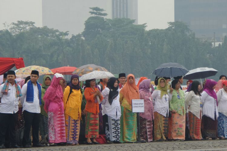 PNS DKI Jakarta mengikuti upacara peringatan HUT ke-490 DKI Jakarta di bawah rintik hujan, Lapangan Silang Monas, Kamis (22/6/2017). 