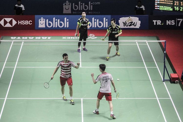 Ganda putra Indonesia Marcus Fernaldi Gideon (kiri, bawah) dan Kevin Sanjaya Sukamuljo (kanan, bawah) melakukan selebrasi usai melawan ganda putra Indonesia Hendra Setiawan dan Mohammad Ahsan pada Indonesian Open 2018 di Istora Senayan, Jakarta, Rabu (4/7/2018). Pasangan Marcus dan Kevin menang dengan skor 21-16, 18-21 dan 21-10.