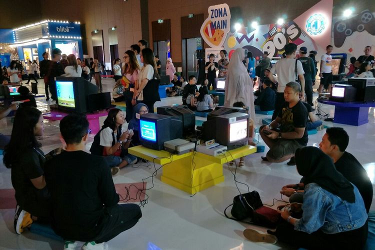 Penonton memainkan console game lawas era 90an di Festival Mesin Waktu di Jiexpo, Kemayoran, Jakarta Pusat, Sabtu (17/8/2019).