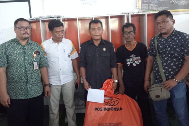 Koordinator Divisi Pengawasan dan Hubungan antar Lembaga Bawaslu Karawang Charles Silalahi dan polisi saat mengecek 247 amplop berisi Tabloid Indonesia Barokah di Kantor Pos Hub Johar, Karawang, Kamis (24/1/2019). Kompas.com