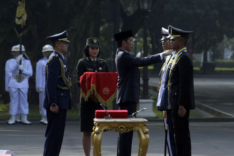 Presiden Joko Widodo saat menyematkan tanda pangkat kepada peraih Adhi Makayasa dalam prosesi upacara pelantikan 724 perwira TNI Polri di halaman Istana Merdeka Jakarta, Kamis (19/7/2018)