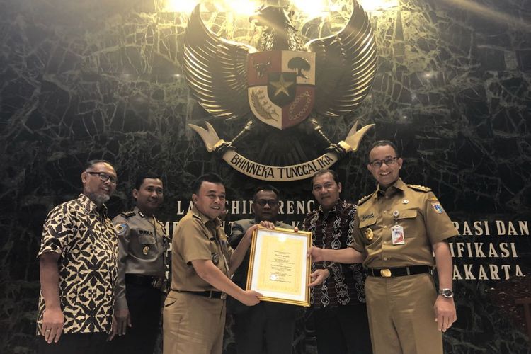 Gubernur DKI Jakarta Anies Baswedan bersama Lurah Kramat Jati Husni Abdullah yang menerima penghargaan karena berhasil menyelamatkan aset, di Balai Kota DKI, Selasa (15/5/2018). 