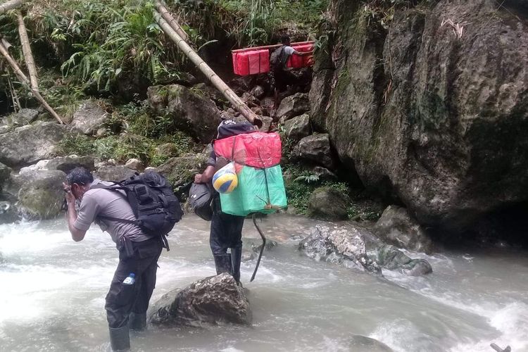 Petugas pengawas Pemilu di Kecamatan Seram Utara Kabupaten Maluku Tengah bersama warga memikul logistik pemilu menyusuri hutan dan sungai menuju desa-desa terpencil di bawah kaki Gunung Binaya, Jumat (12/4/2019).