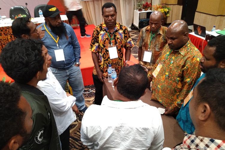 Komisioner KPUD Dogiyai (pakai batik) sedang berdiskusi dengan saksi dari PDIP (baju putih) mengenai perbedaan data yang terjadi di tiga distrik untuk suara DPR RI. Hal ini terjadi ditengah Rapat Pleno Rekapitulasi Suara Provinsi Pqpua pada Pemilu 2019, di Kota Jayapura, Senin (6/05/2019)