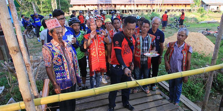 Ketua Panitia Bersepeda di Jantung Borneo didaulat untuk memotong sebilah bambu menggunakan mandau sebelum memasuki Rumah Betang Kedungkang, Sabtu (28/10/2017).