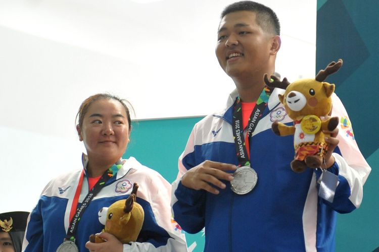 Penembak Chinese Taipei Yichun Lin (kiri) dan Kunpin Yang (kanan) menunjukkan medali perak yang mereka raih pada nomor trap campuran beregu Asian Games 2018 di Final Hall menembak Jakabaring Sport City (JSC), Palembang, Sumatera Selatan, Selasa (21/8/2018). Penembak Lebanon Ray Bassil dan Alain Moussa meraih emas dengan skor 43, pasangan Chinese Taipei ini dengan skor 42, disusul pasangan Cina Xiaojing Wang dan Yu Du meraih perunggu dengan skor 31.  