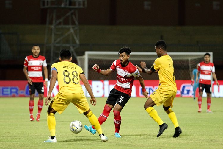 Pemain Madura United, Alfath Faathir (tengah) dijaga ketat pemain Semen Padang pada laga tunda Pekan 7 Liga 1 2019 yang berakhir dengan skor 1-1 di Stadion Gelora Ratu Pamelingan Pamekasan, Jawa Timur, Rabu (28/08/2019) malam.