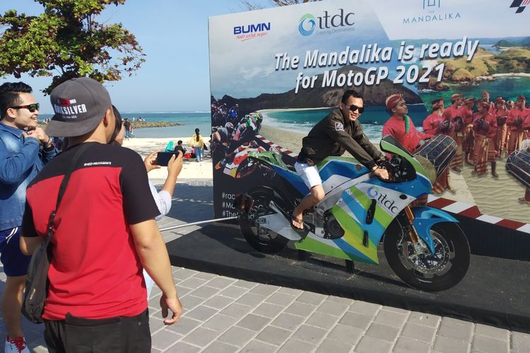 Salah seorang pengunjung sedang berfoto di spot Moto GP di Pantai Kuta Lombok, Nusa Tenggara Barat, Kamis (6/6/2019)