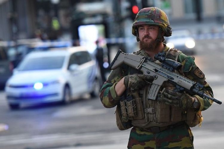 Seorang tentara berjaga-jaga di kawasan di luar stasiun kereta Gare Central, Brussels, Belgia.