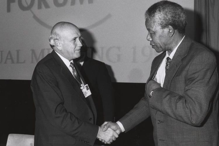 Presiden Afsel FW de Klerk bersalaman dengan pemimpin anti-apartheid Nelson Mandela di World Economic Forum pada 1992.