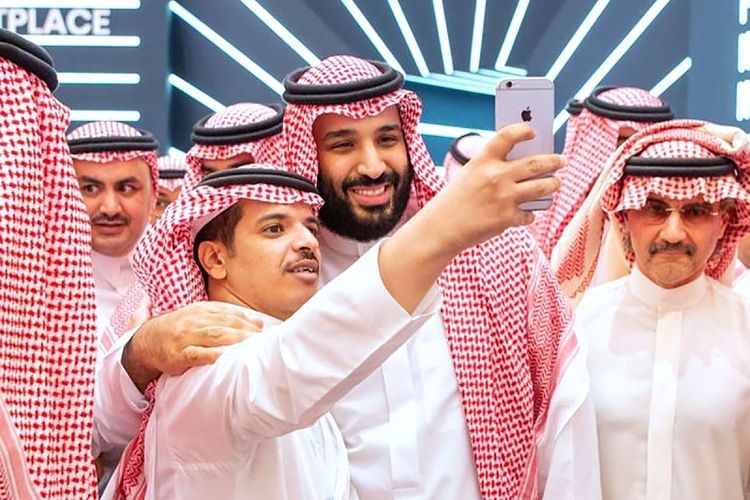 Dalam foto yang dirilis pada Selasa (23/10/2018), putra mahkota Arab Saudi Pangeran Mohammed bin Salman melakukan selfie dengan seorang pria di konferensi Inisiatif Investasi Masa Depan (FII) di Riyadh. Di sebelah MBS nampak miliarder Pangeran Al-Walid bin Talal, yang pernah ditangkap dalam operasi pemberantasan korupsi tahun lalu. 