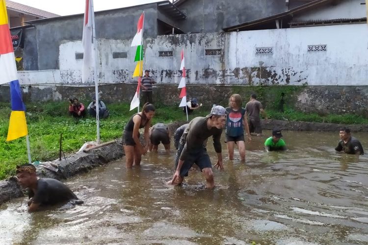 Sejumlah bule asal Belgia mengikuti lomba menangkap lele di kubangan lumpur dalam rangka HUT RI di Desa Kemutug Lor, Kecamatan Baturraden, Kabupaten Banyumas, Jawa Tengah, Sabtu (17/8/2019).