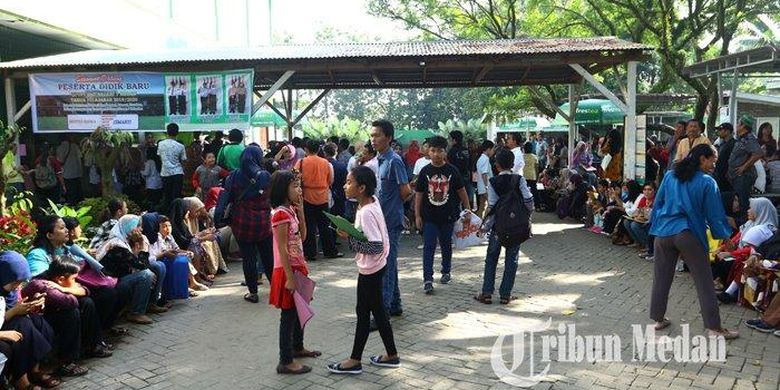 Calon siswa didampingi orangtua/wali murid mengantre saat pendaftaran Penerimaan Peserta Didik Baru (PPDB) Sekolah Menengah Pertama (SMP), di SMP Negeri 1 Medan, Selasa (2/7/2019). PPDB tahun ajaran 2019/2020 tingkat SMP di Kota Medan dibuka mulai hari ini, Selasa 2 Juli hingga Sabtu 6 Juli 2019. (M Daniel Effendi Siregar)