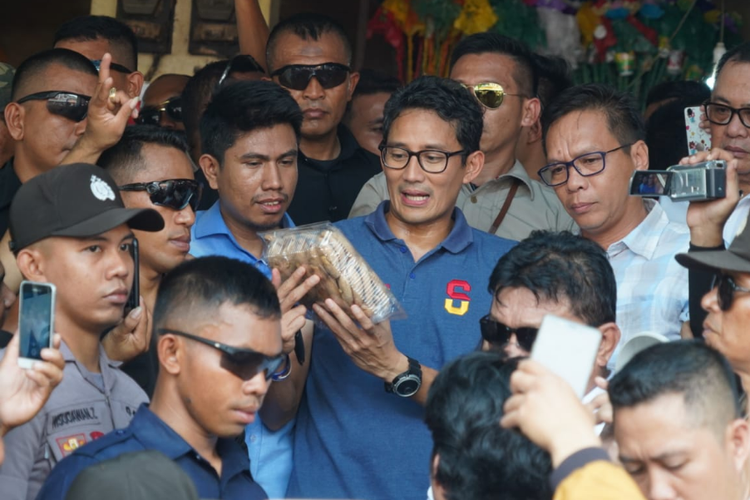 Sandiaga Uno memperlihatkan kue Bagea yang dibeli dari pedagang di Pasar Mandonga, Kendari.