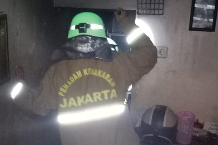 Petugas pemadam kebakaran saat bertugas memadamkan api di sebuah rumah tinggal di kawasan Rawa Bunga, Rabu (26/6/2019).