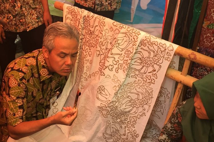 Gubernur Jawa Tengah Ganjar Pranowo memegang canting untuk ditorehkan ke kain mori pada peringatan Hari Batik di Kabupaten Banyumas, Senin (2/10/2017).