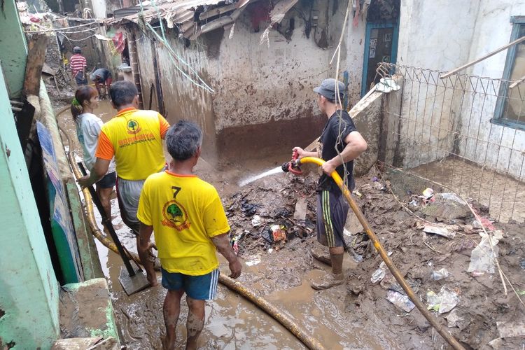 Warga RW 08 Kelurahan Pejaten Timur, Jakarta Selatan membersihkan lumpur bekas banjir, Senin (29/4/2019).