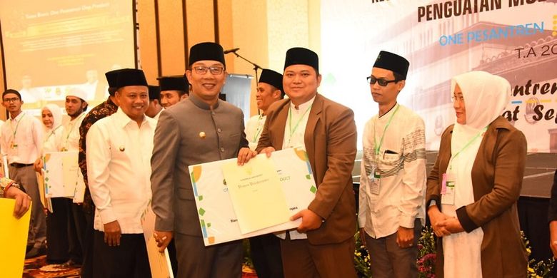 Gubernur Jawa Barat Ridwan Kamil dan Wakil Gubernur Jawa Barat Uu Ruzhanul Ulum menyerahkan hadiah kepada pondok pesantren (ponpes) peserta One Pesantren One Product (OPOP) di Bandung, Selasa (3/9/19).
