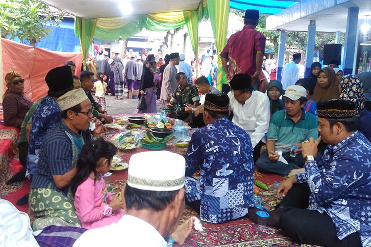 Warga Desa Pongangan, Kecamatan Manyar, Gresik, Jawa Timur bersama Muspika setempat ketika menikmati tumpeng dalam Peringatan Haul KH Syafii, Selasa (16/1/2018).
