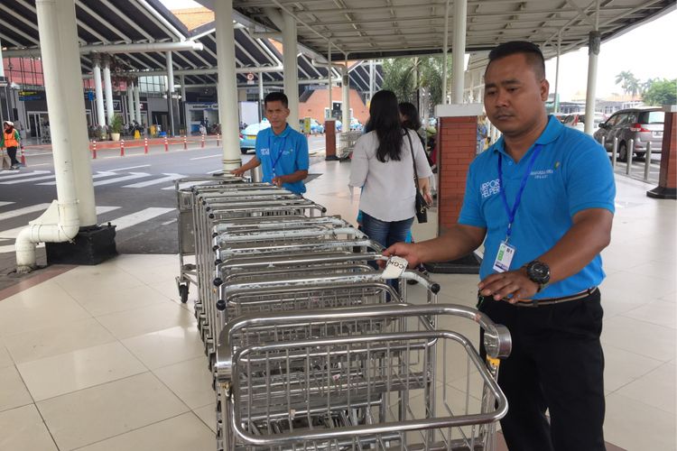 Sejumlah petugas airport helper bekerja di area Terminal 1 Bandara Soekarno-Hatta, Tangerang, Sabtu (2/9/2017). Para porter kini berubah menjadi airport helper dan pengumpul troli, sehingga mereka kini digaji dan tidak diperbolehkan menerima uang tip.