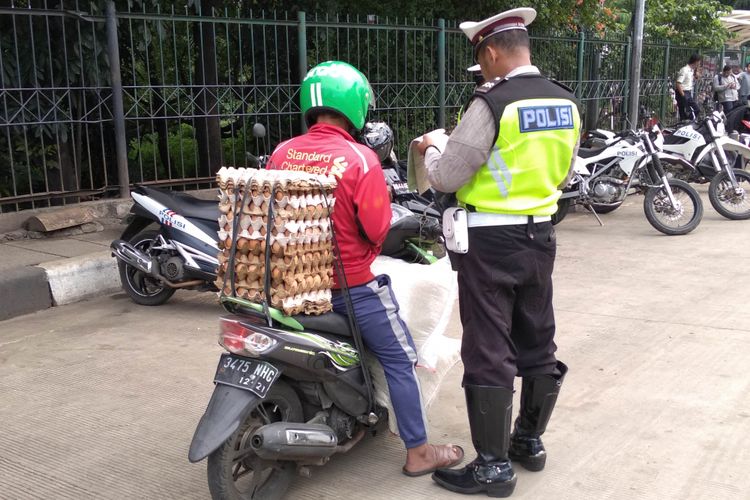 Sepeda motor membawa beban berlebih terjari Operasi Keselamatan Jaya di UKI, Jumat (9/3/2018)
