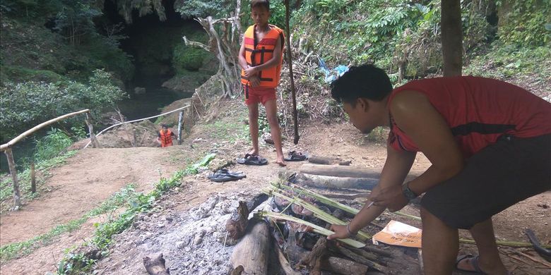 Usai lelah bermain air, wisatawan membakar ikan di area Goa Lalay, Pangandaran, Jawa Barat.