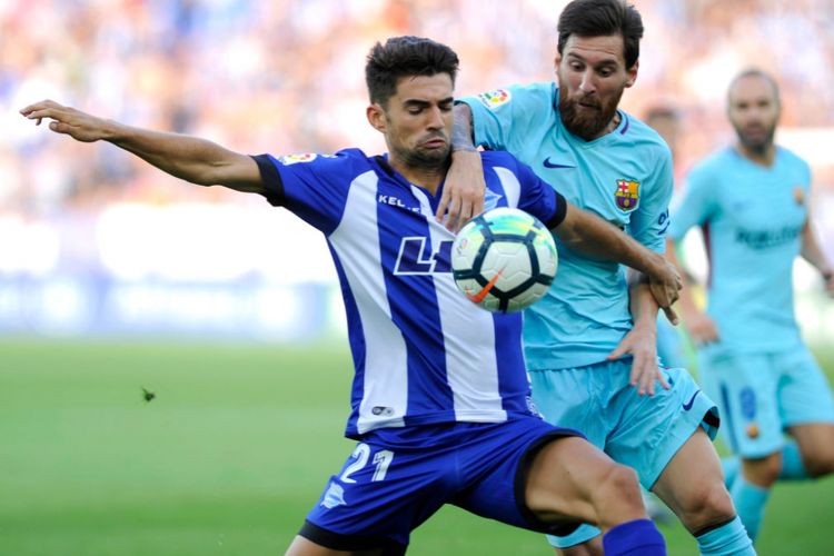 Lionel Messi dicegat Enzo Fernandez pada pertandingan Barcelona kontra Alaves, Sabtu (26/8/2017). 