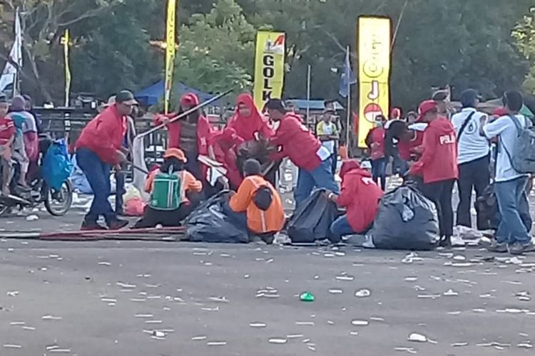 Sejumlah relawan memungut sampah usai kampanye terbuka yang digelar capres nomer urut 01 Jokowi di Batam, Sabtu (6/4/2019).