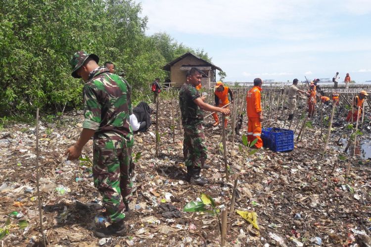 Empa puluh lima personil tentaa diterjunka untuk membersihkan lautan sampah di Muara Angke, Jakarta Utara