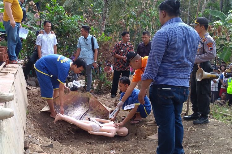 Tersangka Irvan (32) dan Putra (27) melakukan adegan mengubur jasad korban di kebun belakang rumah Misem (76) warga Grumbul Karanggandul, Desa Pasinggangan, Kecamatan/Kabupaten Banyumas, Jawa Tengah, Rabu (28/8/2019).