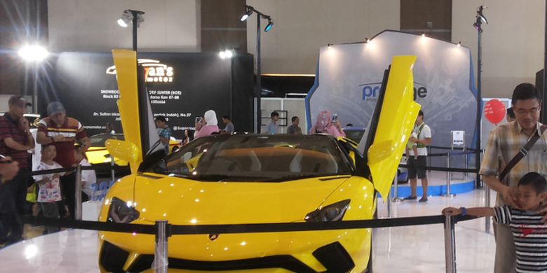 Pengunjung IIMS sedang berpose di depan salah satu Lamborghini yang dipajang di stan Prestige pada hari ketiga penyelenggaraan ajang Indonesia International Motor Show (IIMS) 2018 di JIExpo Kemayoran, Jakarta, Sabtu (21/4/2018).