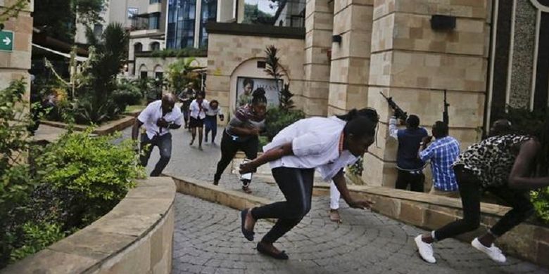 Warga sipil kompleks hotel di Nairobi, Kenya, menunduk sembari melarikan diri dengan pasukan keamanan (kanan) menembak ketika serangan terjadi pada Selasa (15/1/2019).