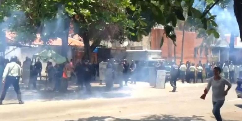 Keluarga dari tahanan di Penjara Valencia, Venezuela berhamburan setelah polisi menembakkan gas air mata Rabu (28/3/2018).  Terjadi kerusuhan di sana setelah sekelompok tahanan berusaha melarikan diri dengan meledakkan kasur.