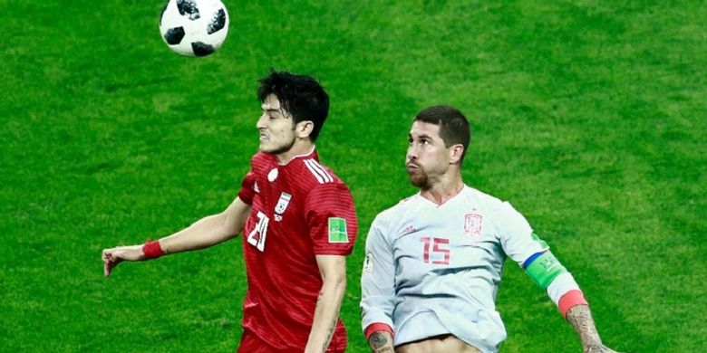 Sardar Azmoun dan Sergio Ramos berduel di udara dalam memperebutkan bola pada pertandingan Iran vs Spanyol di Kazan Arena, 20 Juni 2018. 