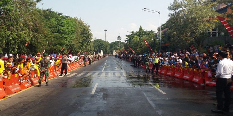 Masyarakat Kota Solo menunggu datangnya pawai obor Asian Games 2018 di Jalan Jenderal Sudirman, Solo, Kamis (19/7/2018) siang.