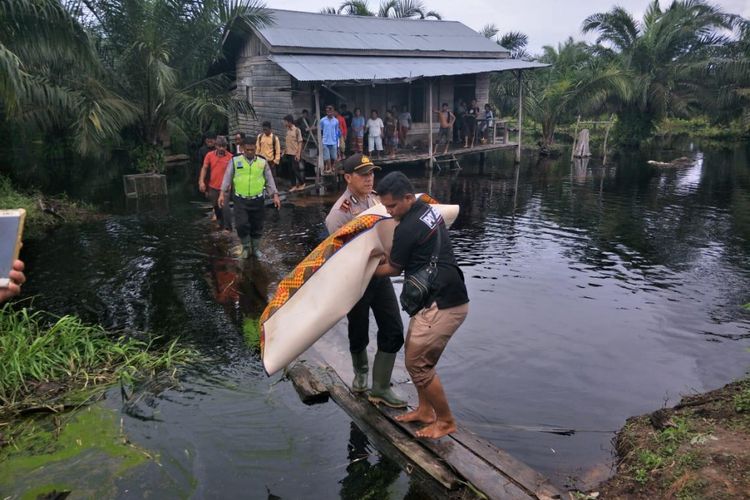 Kapolsek Bonai Darussalam Iptu Riza Effyandi dan anggotanya mengevakuasi seorang bocah yang tewas diterkam buaya di Desa Sontang, Kecamatan Bonai Darussalam, Rokan Hulu, Riau, Kamis (15/11/2018).