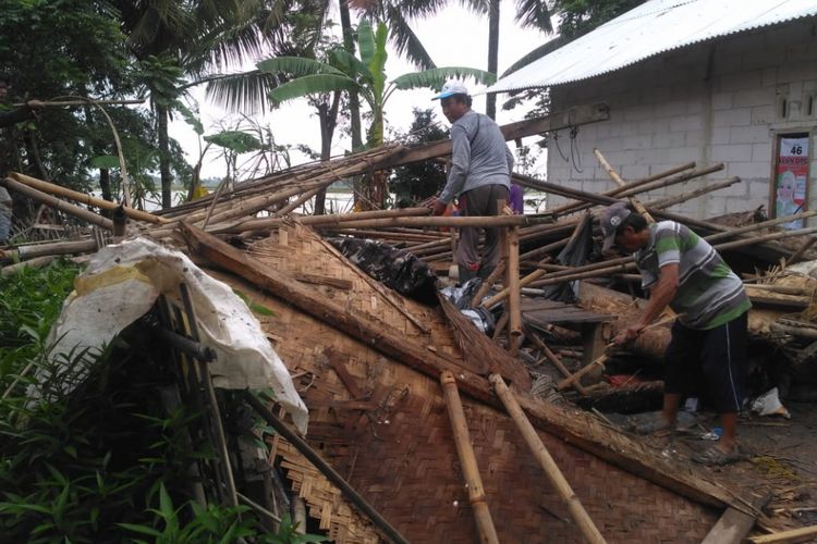 Warga Desa Pusakajaya Utara, Kecamatan Cilebar, Kabupaten Karawang tengah membersikan puing-puing rumah yang rusak akibat terjangan puting beliung, Minggu (27/1/2019).
