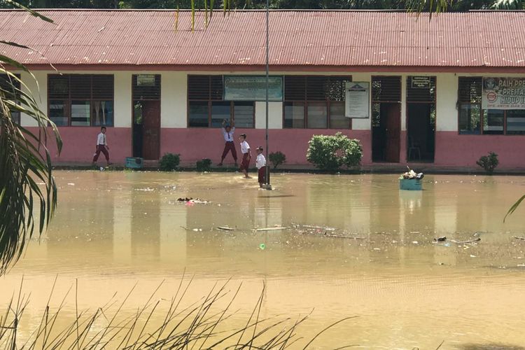 Banjir merendam halaman Sekolah Dasar Negeri 03 Desa Kasang Mungkal, Kecamatan Bonai Darussalam, Kabupaten Rohul, Riau, Selasa (16/10/2018). Aktivitas belajar mengajar di sekolah itu masih berjalan normal. Banjir ini diakibatkan luapan air sungai Rokan Kiri, Rohul