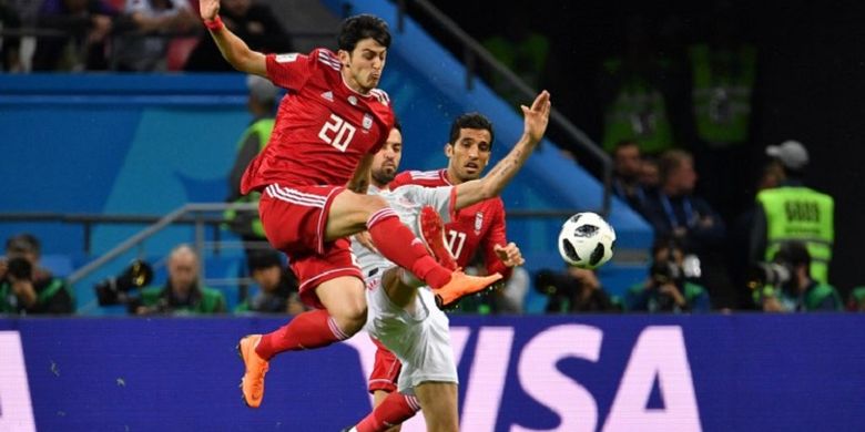 Sardar Azmoun bergerak lebih cepat daripada Sergio Busquets  dalam menyongsong bola pada pertandingan Iran vs Spanyol di Kazan Arena, 20 Juni 2018. 