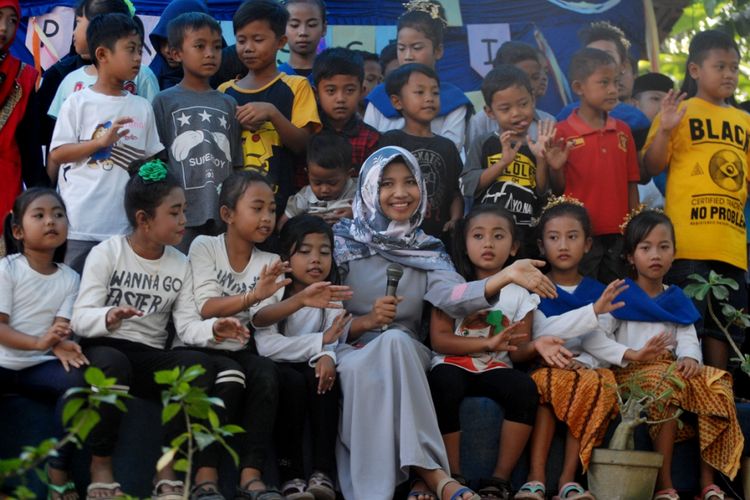 Febri Mustikawati (22), Penggagas Taman Baca Golek Ilmu saat bernyanyi bersama anak-anak dalam acara pentas seni bersama Gramedia di Dusun Welahan, Desa Tambakselo, Kecamatan Wirosari, Kabupaten Grobogan, Jawa Tengah, Minggu (9/7/2017).