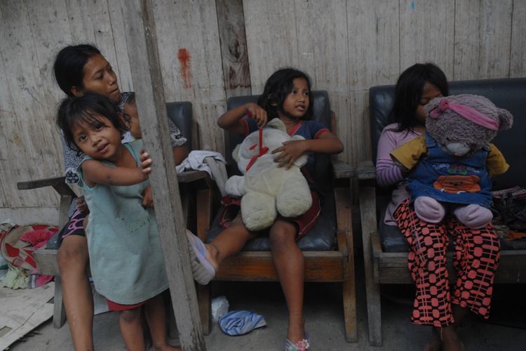Purwanti Endang Adinda Lestari (10) dan Alinda Susi Lestari (9) duduk bersama ibu serta kedua adiknya di rumahnya di Kelurahan Getasrejo, Kecamatan Grobogan, Kabupaten Grobogan, Jateng, Senin (16/4/2018) siang.