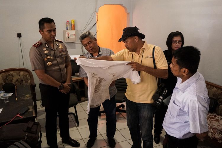 Sejumlah wartawan memperlihatkan baju Darbe Tyas Waskitha, jurnalis Metro TV yang penuh dengan bekas tapak sepatu aparat yang menginjak-injak dirinya saat meliput aksi unjuk rasa di depan kantor Bupati Banyumas, Senin (9/10/2017) malam.
