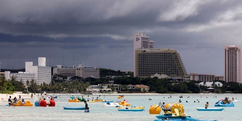 Para turis sedang bermain di perairan di depan jajaran hotel mewah di kawasan distrik wisata Tumon di Guam, 10 Agustus 2017.

