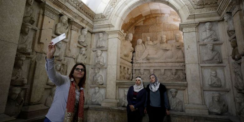 Para pengunjung berfoto di salah satu seksi Museum Nasional Suriah. Museum tersebut kembali dibuka setelah ditutup pada 2012 akibat perang sipil yang berkecamuk.