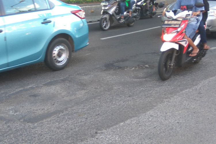 Jalan D.I. Panjaitan, Jakarta Timur, dalam kondisi rusak dan bergelombang, Kamis (25/1/2018)